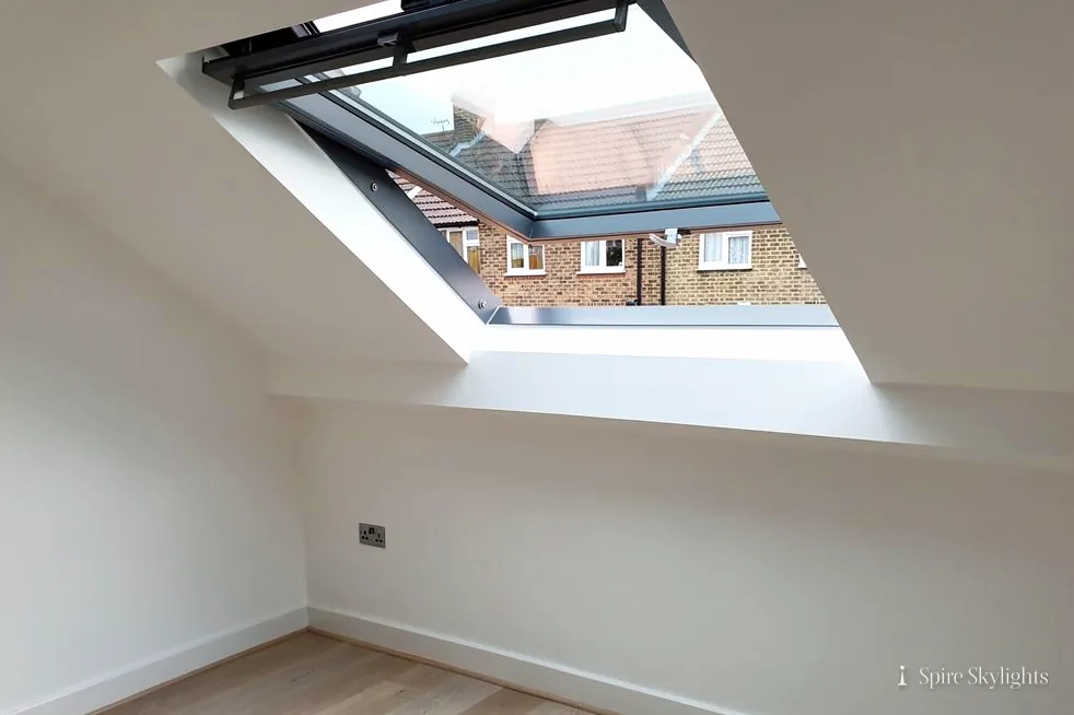 Roof window open on the sloping ceiling of a loft room