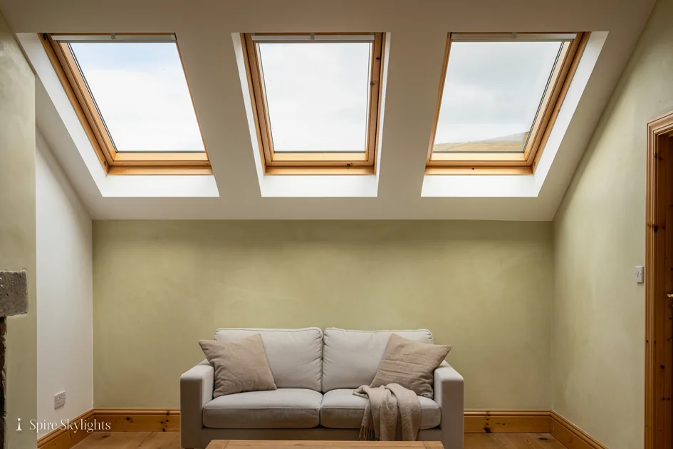 Living room under a vaulted ceiling lit by three roof windows