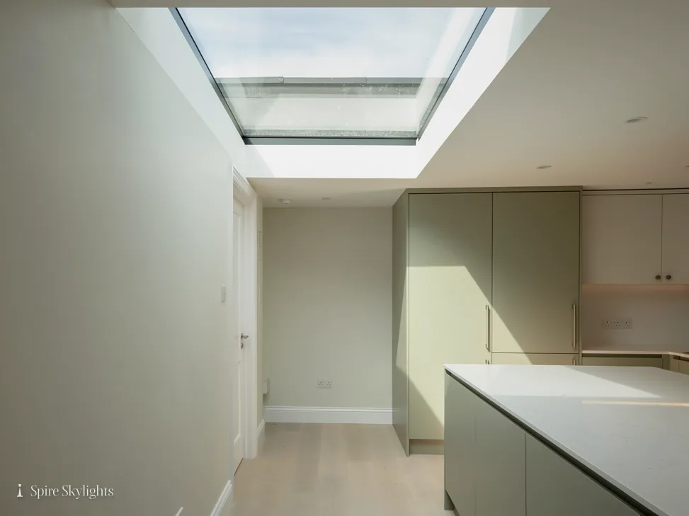 Large flat rooflight over a kitchen, its reveal plastered and painted white