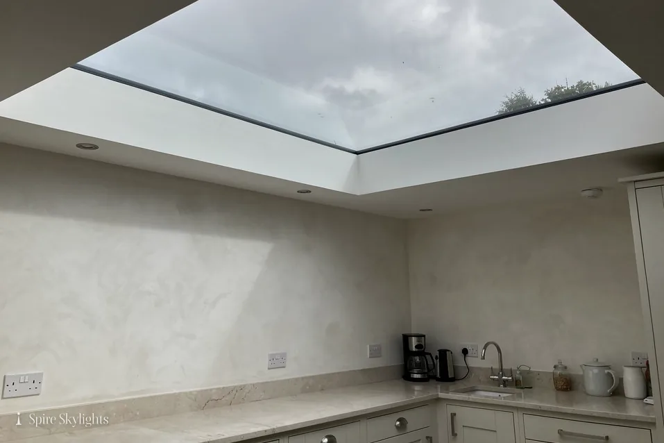 Flat rooflight above a kitchen worktop, its deep reveal plastered smooth