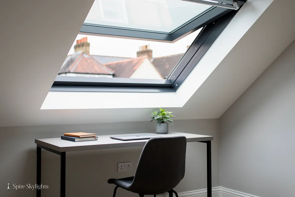 Loft home office with a roof window open above the desk