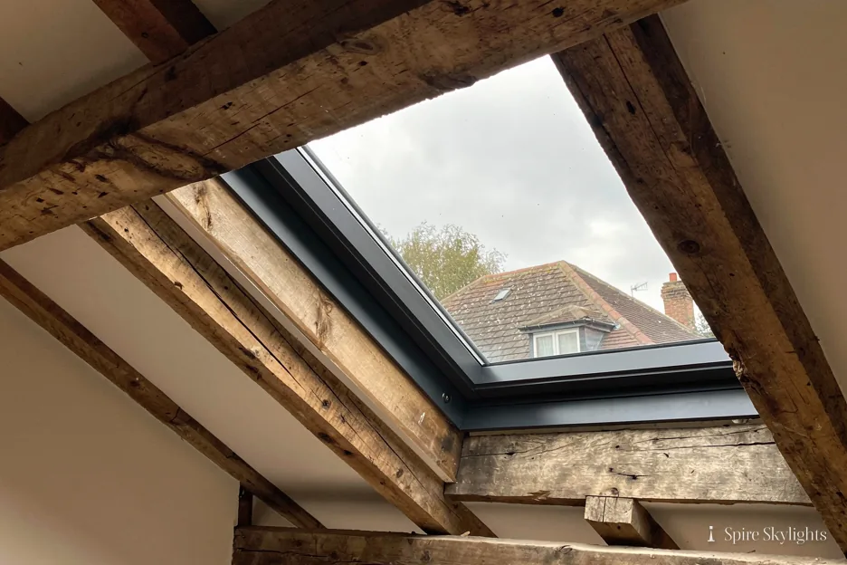 Roof window set between old timber rafters in a loft room