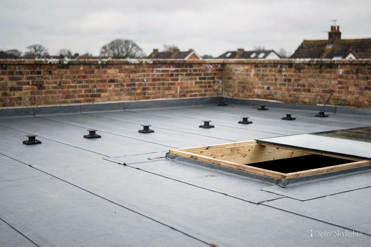 Newly laid flat roof with a rooflight upstand around an uncovered opening