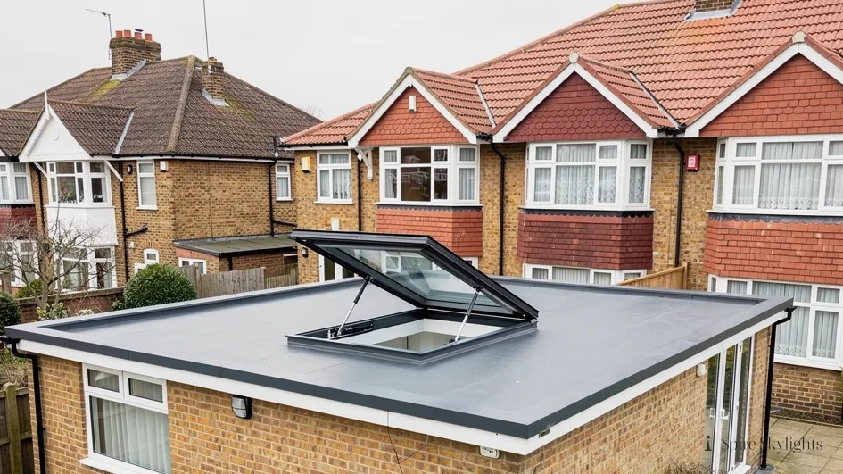 Hinged rooflight standing open on a brick extension behind 1930s semis