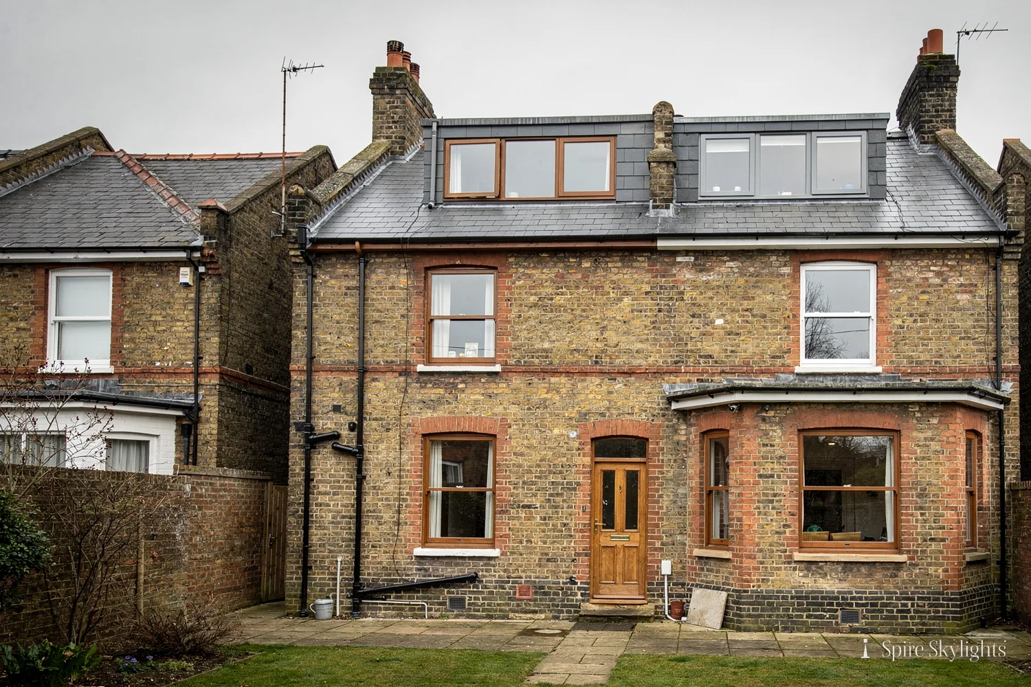 Victorian brick semi seen from the garden, with roof windows in the slate roof