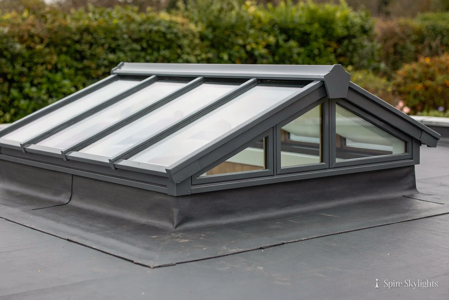 Ridged glass rooflight sitting on a single-ply flat roof