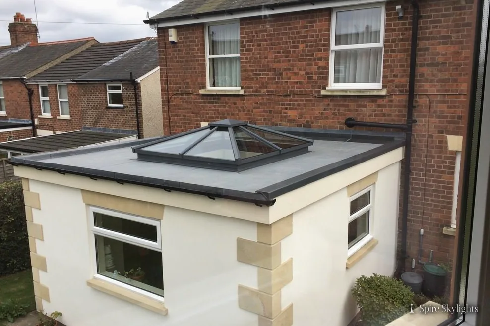 Rendered extension with a roof lantern beside a red-brick terrace