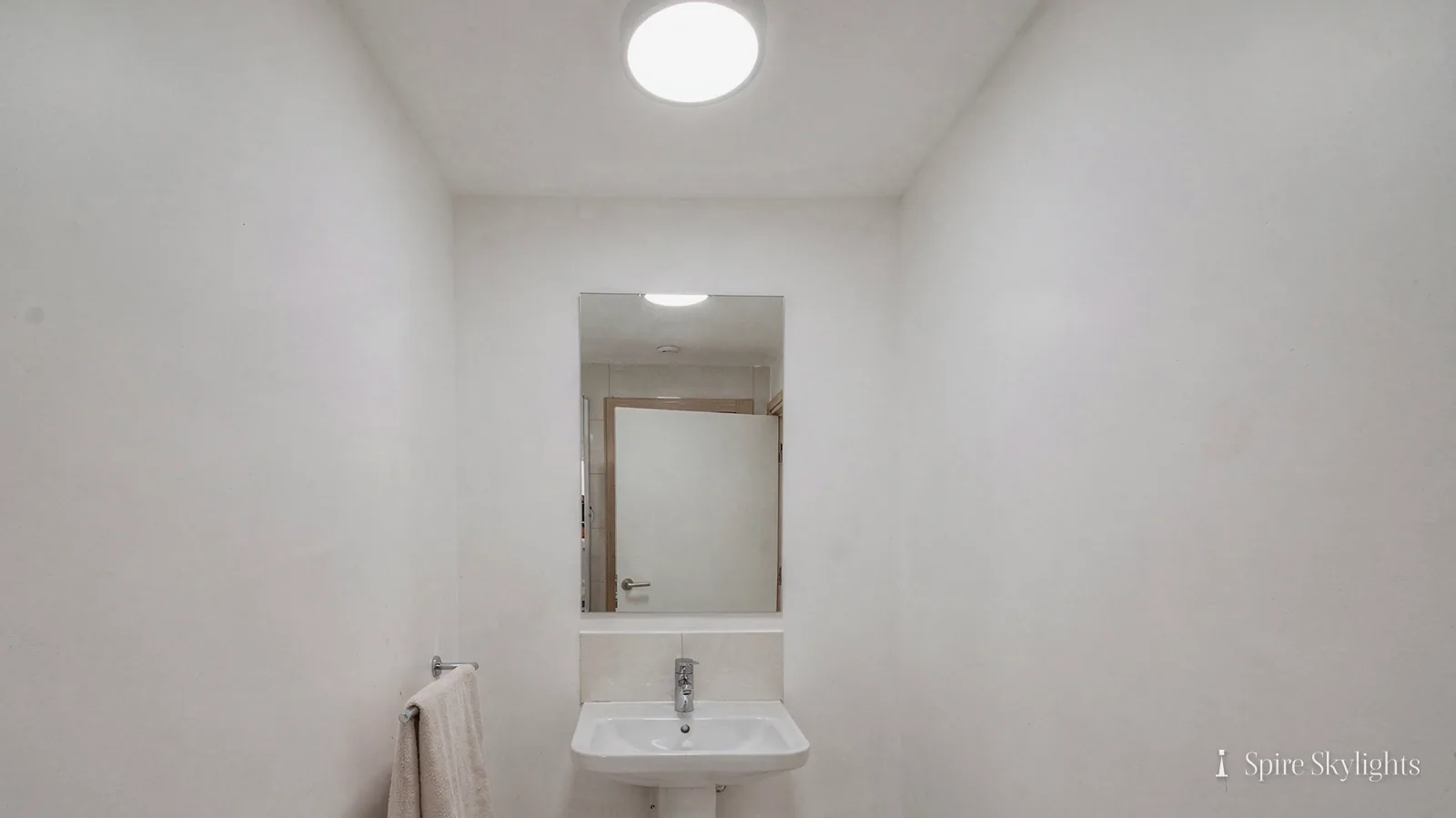 Small cloakroom lit by a round sun tunnel diffuser