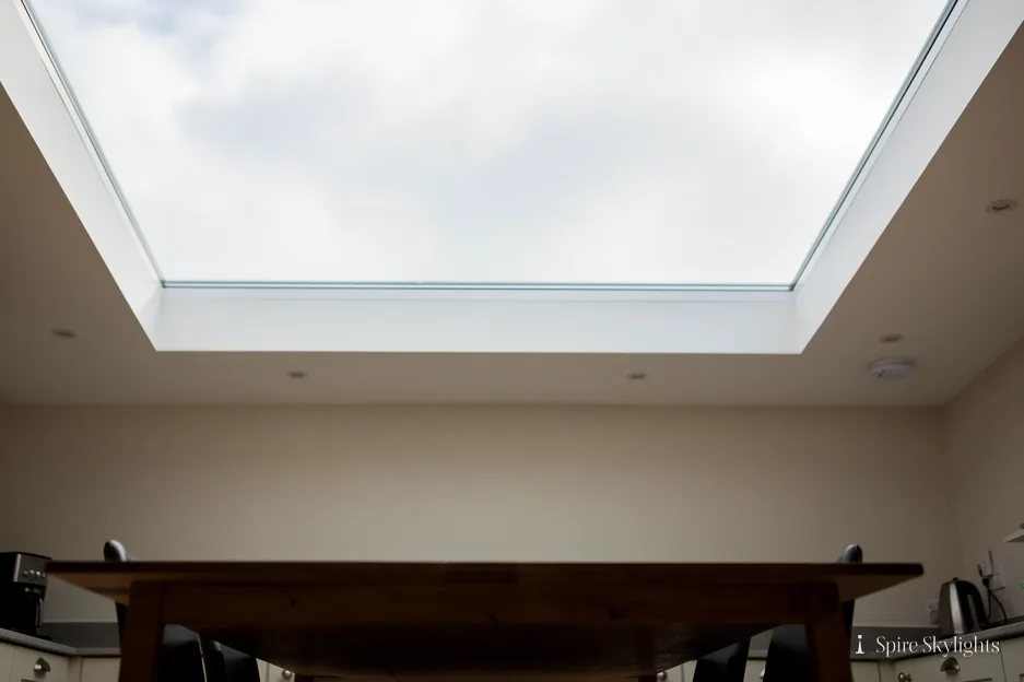 Large flat rooflight seen from below, framed by a white plastered reveal